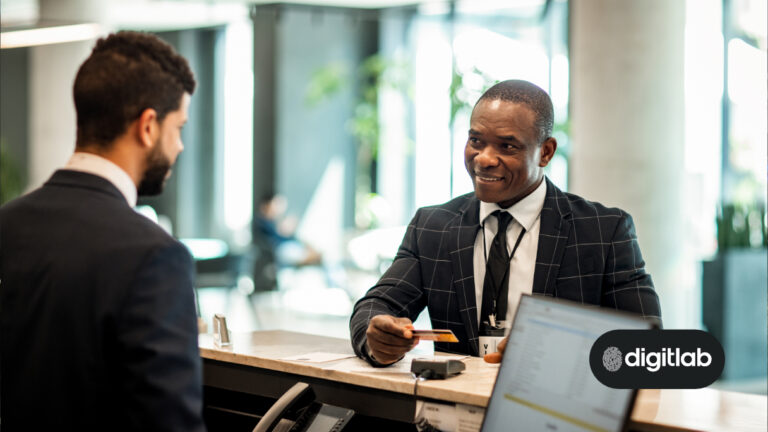 Increase direct bookings using a website - african man holding a credit card standing at hotel reception.
