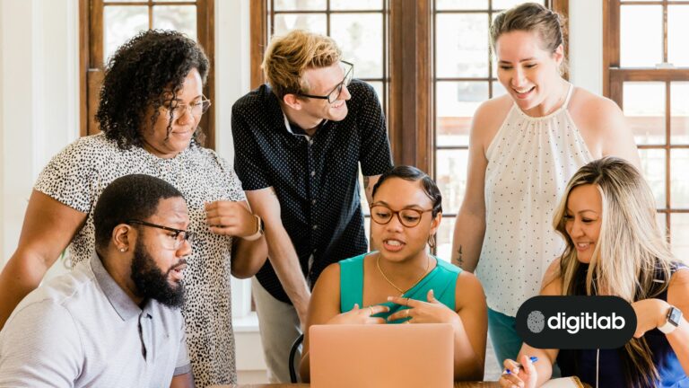 HubSpot onboarding - team of marketers standing around a laptop.