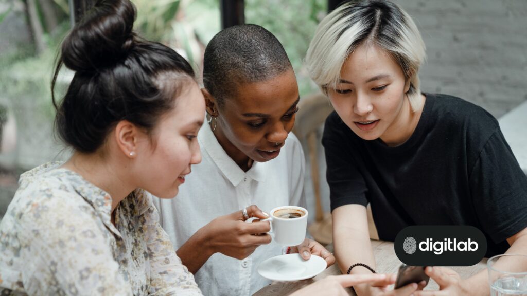 Startup social media marketing - three women looking at a smartphone with interest.