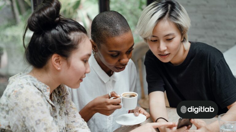 Startup social media marketing - three women looking at a smartphone with interest.