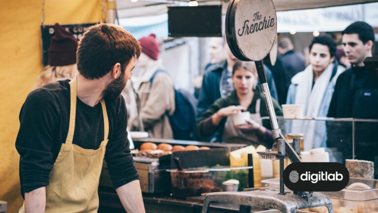 Strategies for taking a startup to market - man in a shop looking at customers behind counter.